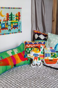 cama infantil com colcha matelassada e almofadas