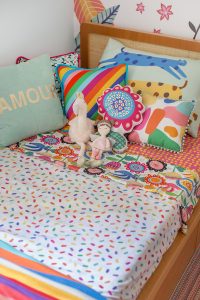 cama infantil com lençóis estampados coloridos