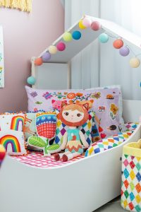 almofadas coloridas em cama infantil casinha