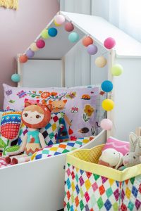 detalhe de cama infantil com almofadas coloridas