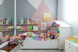quarto infantil com parede geométrica rosa e cinza