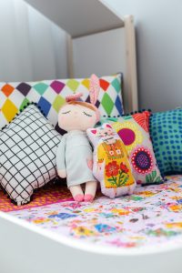 almofadas coloridas na cama infantil