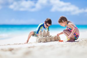 crianças e castelo de areia na praia