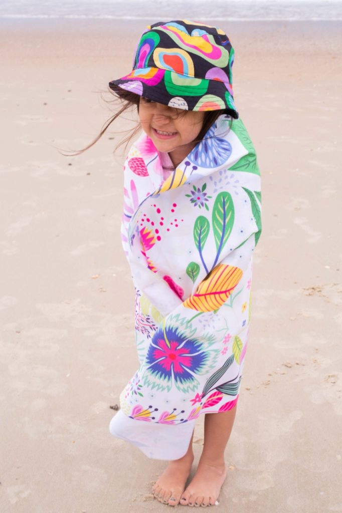 praia com criança proteção chapéu