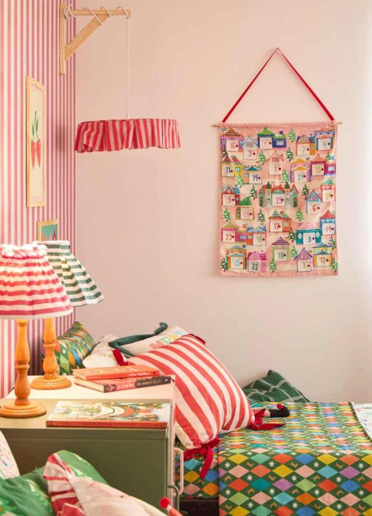 Quarto decorado para o Natal com calendário do Advento de vilarejo colorido pendurado na parede.