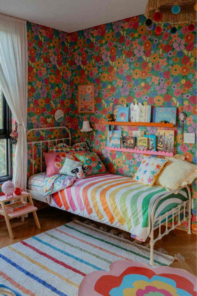 Quarto feminino, cama com tapete livros em cima e uma cabeça de vaquinha infantil na cama.

