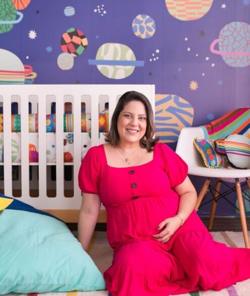 Mãe com vestido rosa em quarto infantil decorado