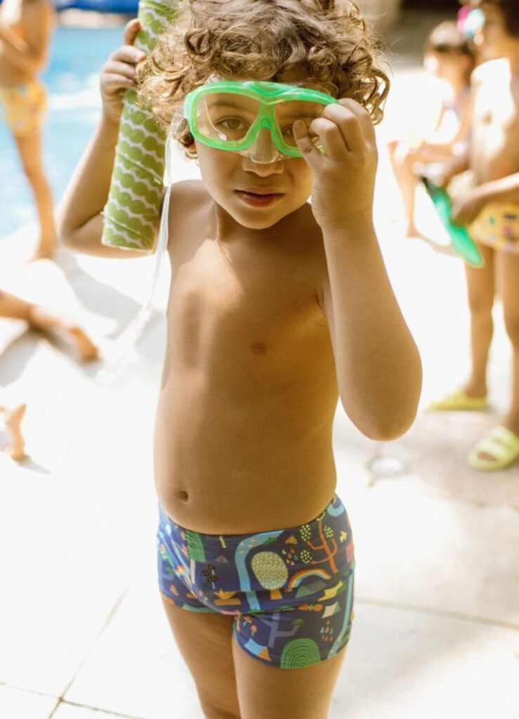 Menino com sunga e roupas de natação