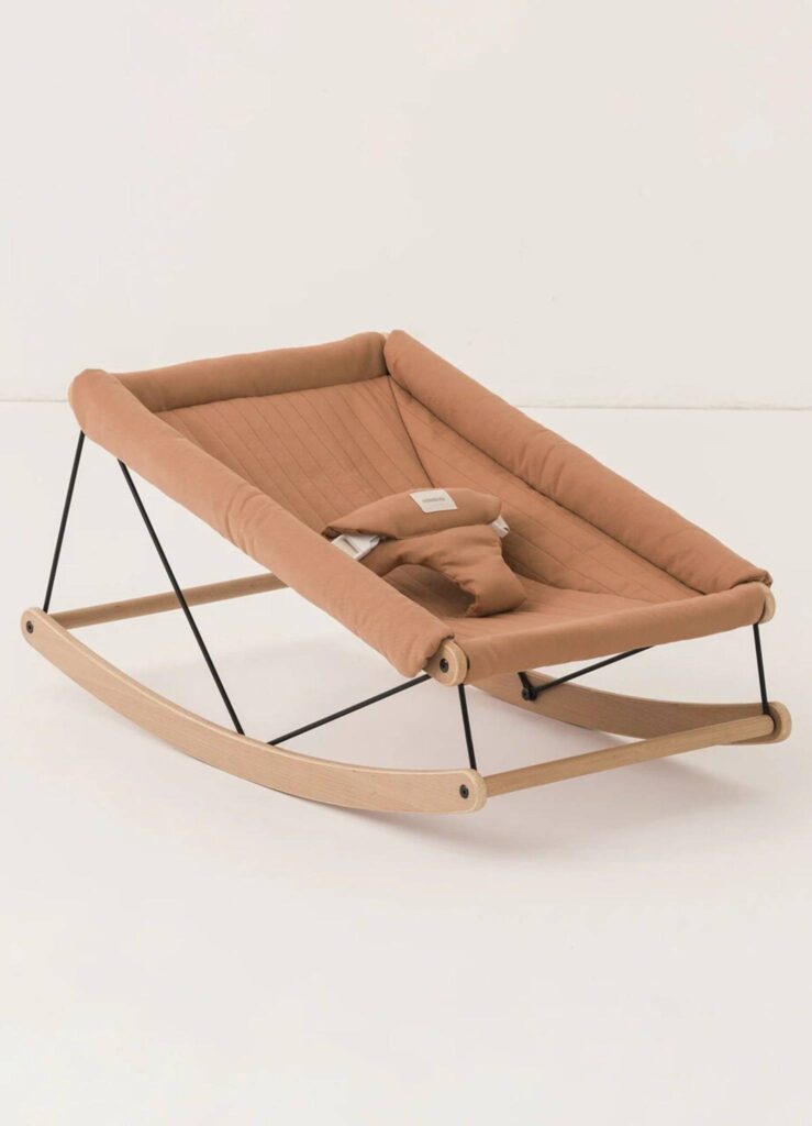 Cadeira de descanso infantil em madeira clara com estofado marrom, design moderno e minimalista.