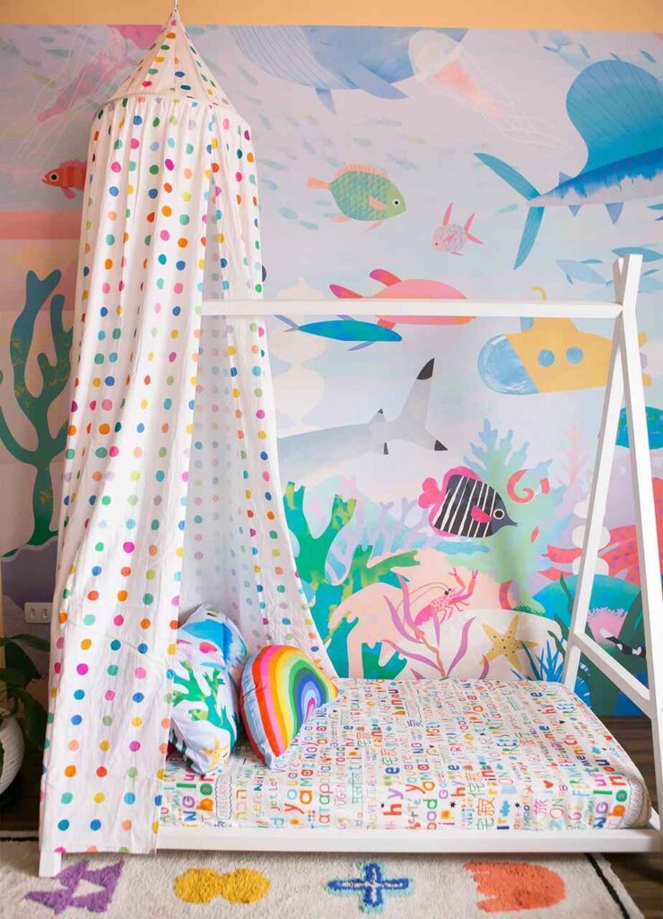 quarto de bebê pequeno com papel de parede e luminária MOOUI