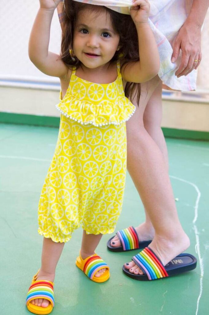 Menina com apoio da mãe, momento de aprendizado no desfralde.