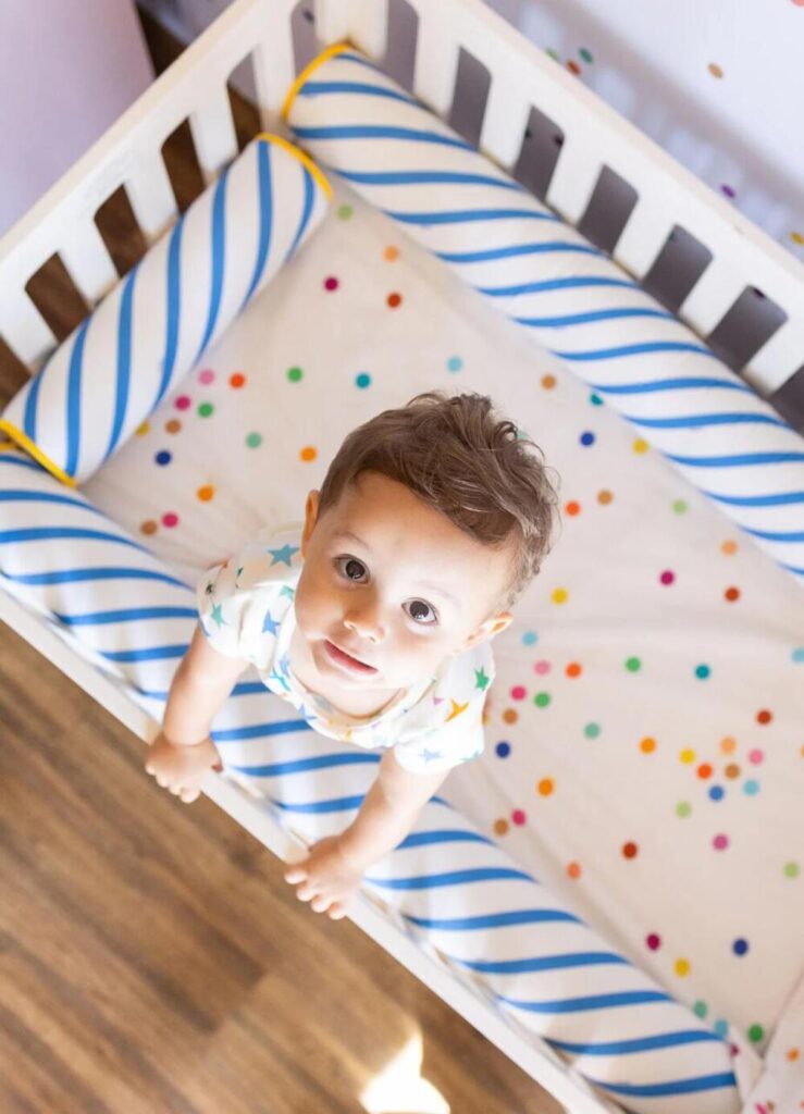 Bebê menino no berço, fase inicial do desfralde infantil.