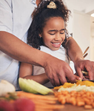 Mãe e filha preparando hambúrguer de atum saudável juntas na cozinha.