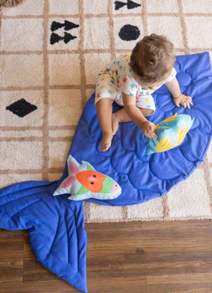 Criança brincando no tapete em quarto infantil, ambiente acolhedor na angústia da separação.