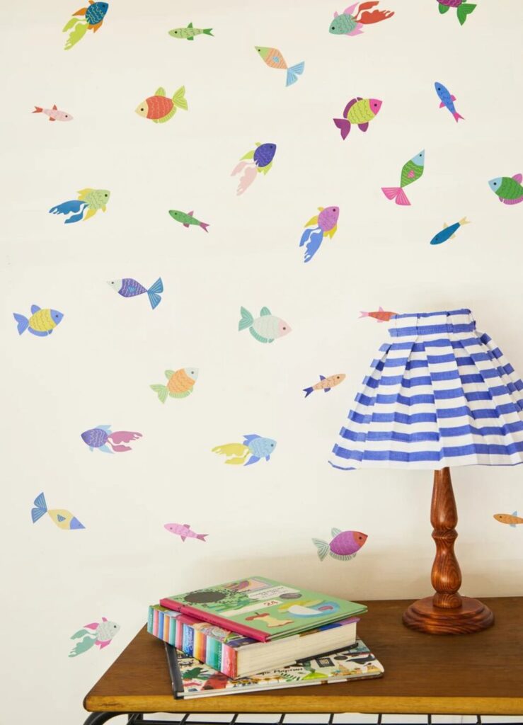 Adesivo decorativo infantil com peixes coloridos criando tema fundo do mar para quarto de criança.