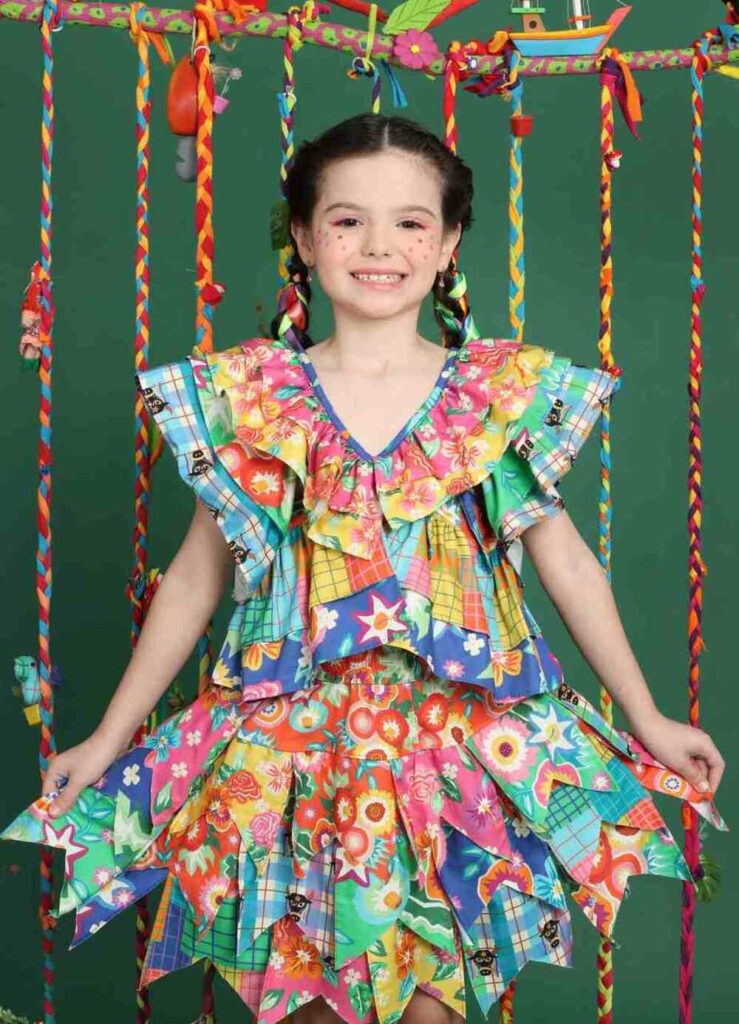 Blusa infantil de festa caipira com babados, mistura de estampas e cores vibrantes.