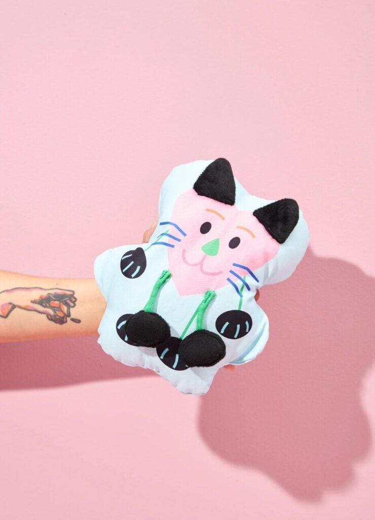 Almofada infantil divertida em formato de gatinho para decoração lúdica e universo criativo infantil.