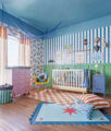 Quarto de bebê colorido com berço, tapete e móveis planejados, ambiente alegre e funcional para primeiros meses.