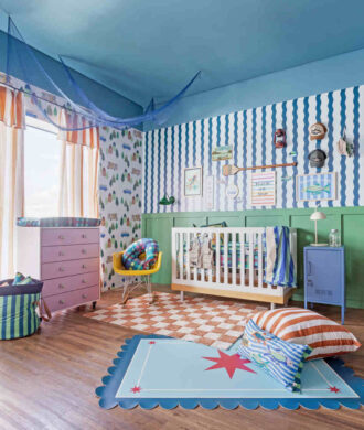 Quarto de bebê colorido com berço, tapete e móveis planejados, ambiente alegre e funcional para primeiros meses.
