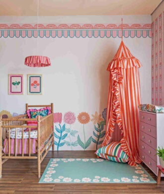 Tapete para quarto de bebê em tom verde com flores, compondo decoração colorida e lúdica com berço e dossel.