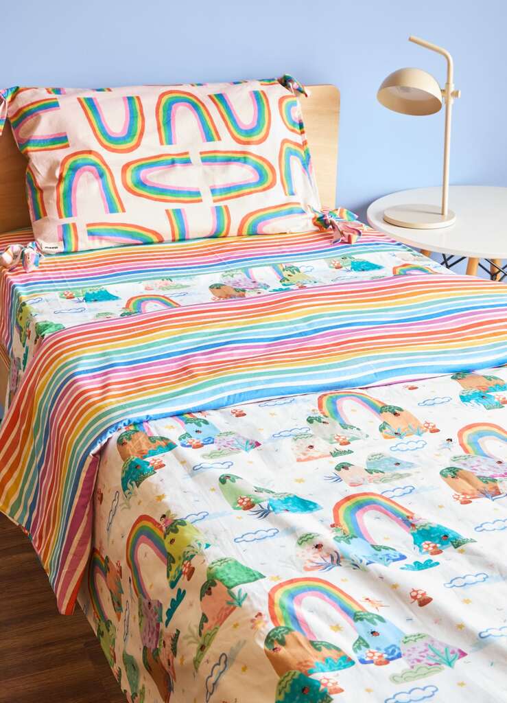 Roupa de cama infantil solteiro com estampas de arco-íris e fadas, ideal para quartos delicados e coloridos.