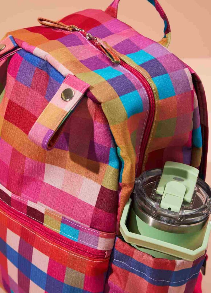 Detalhe da mochila maternidade com bolso lateral para garrafa e acabamento reforçado, ideal para passeios e consultas.