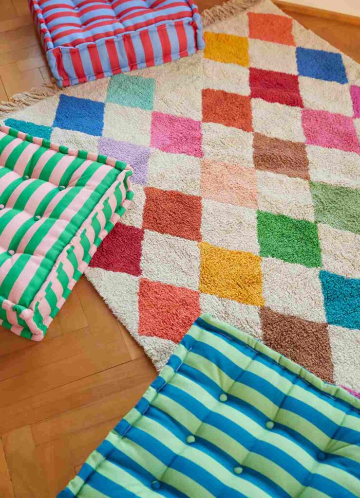 Tapete infantil de algodão com estampa de losangos coloridos, ideal para criar um cantinho de brincar aconchegante.