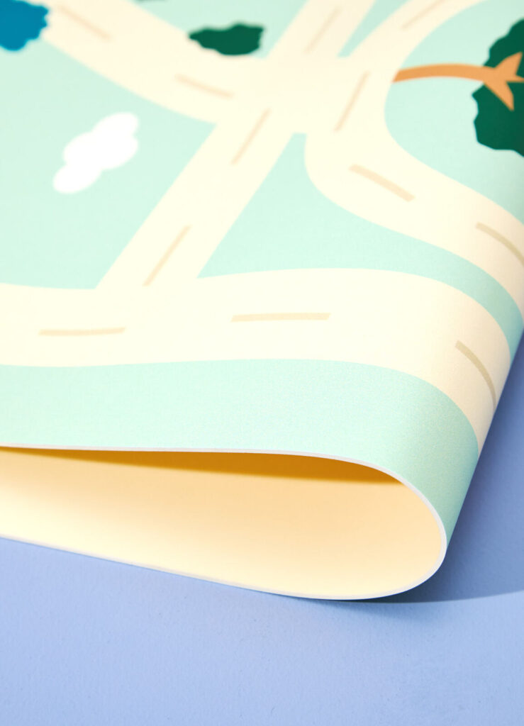 Detalhe do playmat acolchoado infantil com estampa de cidade, acabamento dobrável e superfície confortável.